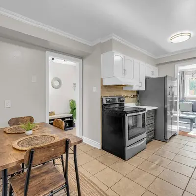 a kitchen with a table and a stove top oven at Retro Arcade & Gaming Home by Pako Stays in Brampton