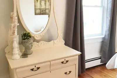a white dresser with a mirror on top of it at Gwyn Haven - Spacious Charming Century Home in Wellington in Wellington