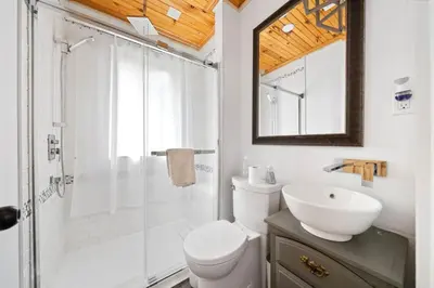 a bathroom with a shower and a toilet and a sink at Westlake waterfront, hot tub, dock,4 mins to beach in West Lake