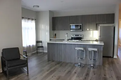 a kitchen with a counter and a refrigerator at Boardwalk Homes - Executive Townhomes in Kitchener