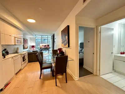a kitchen and dining room with a table and chairs at 1Bdrm plus den with 2 real beds plus sofabed & Terrace & parking in Toronto