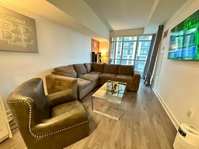 a living room with a couch and a table at 1Bdrm plus den with 2 real beds plus sofabed & Terrace & parking in Toronto