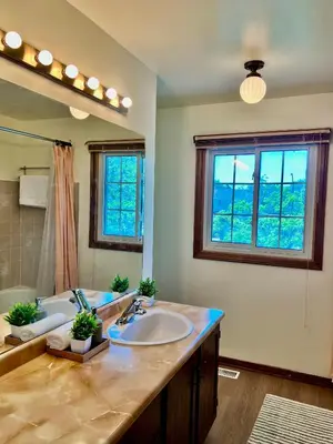 a bathroom with a sink and a large mirror at Entire Cozy House in Thorold in Thorold
