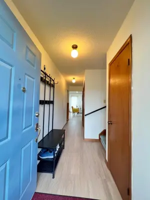 a hallway with a blue door and a room at Entire Cozy House in Thorold in Thorold