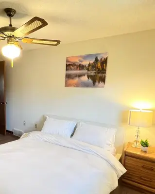 a bedroom with a white bed and a painting on the wall at Entire Cozy House in Thorold in Thorold