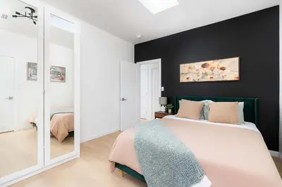 a bedroom with a large bed and a mirror at Large Victorian Sleeps 6 by UofT in Toronto