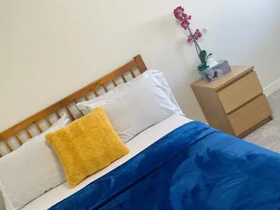 a bed with blue and white sheets and a yellow pillow at New Cosy bright and Spacious Apartment in East Gwillimbury
