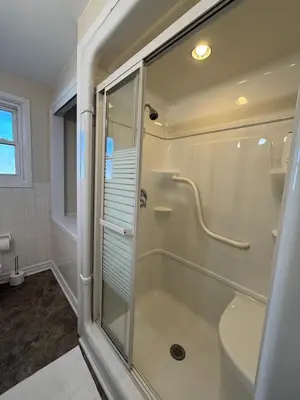 a shower with a glass door in a bathroom at Niagra Luxury Home in Thorold