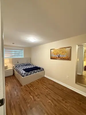 a bedroom with a bed and a painting on the wall at Niagra Luxury Home in Thorold