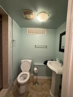 a bathroom with a toilet and a sink at Niagra Luxury Home in Thorold
