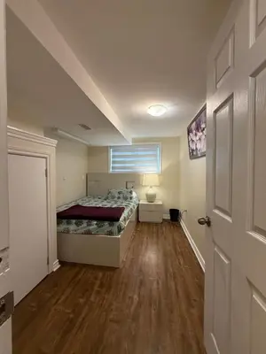 a small bedroom with a bed and a door at Niagra Luxury Home in Thorold