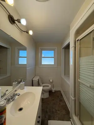 a bathroom with a sink and a toilet and a mirror at Niagra Luxury Home in Thorold
