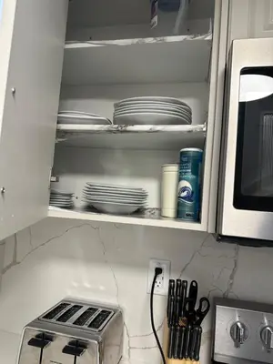 a kitchen shelf with plates and a microwave at Cozy Home away in Ajax 2 BR 1 bath 4 guests in Ajax