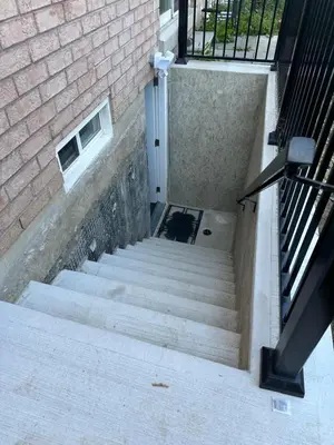 a set of stairs leading up to a brick building at Cozy Home away in Ajax 2 BR 1 bath 4 guests in Ajax
