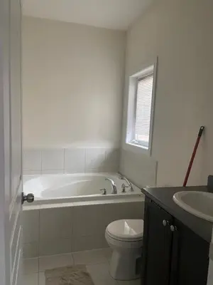 a bathroom with a tub and a toilet and a sink at Divinity Hut in Brampton