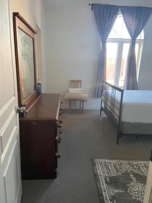 a bedroom with a bed and a dresser and a window at Divinity Hut in Brampton
