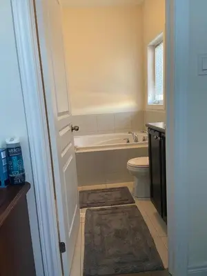 a bathroom with a tub and a toilet and a sink at Divinity Hut in Brampton