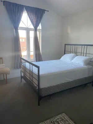 a bed in a bedroom with a large window at Divinity Hut in Brampton