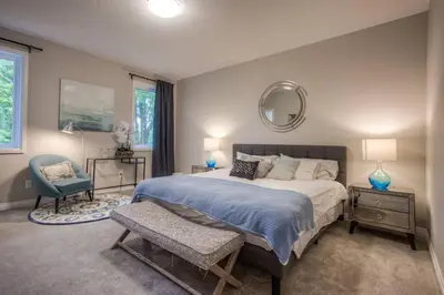 a bedroom with a bed and a chair and a mirror at BRAND-NEW LUXURY SUITE in DOON SOUTH, min to 401 in Kitchener