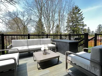 a patio with couches and a table on a deck at BRAND-NEW LUXURY SUITE in DOON SOUTH, min to 401 in Kitchener