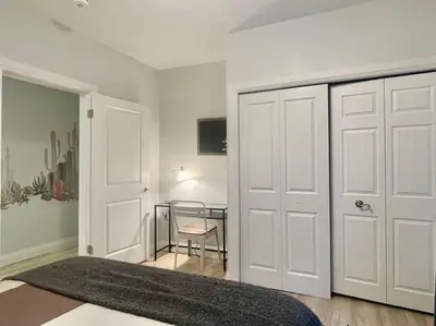 a bedroom with a white door and a table at Stylish 3-bdrm suite w free Parking in Kitchener