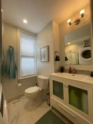 a bathroom with a toilet and a sink and a mirror at Stylish 3-bdrm suite w free Parking in Kitchener