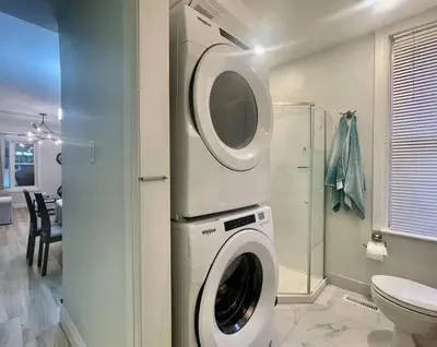 a washing machine in a bathroom with a toilet at Stylish 3-bdrm suite w free Parking in Kitchener