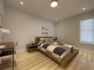a bedroom with a bed and a desk in it at Stylish 3-bdrm suite w free Parking in Kitchener