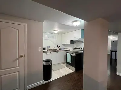 a kitchen with white cabinets and an open door at Home by Dolly in Toronto
