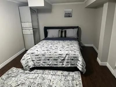 a bedroom with a bed with a comforter and a rug at Home by Dolly in Toronto