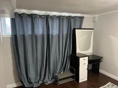 a room with a curtain and a desk and a mirror at Home by Dolly in Toronto