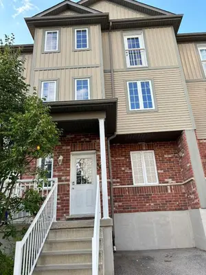 a house with a white door and stairs at Room in neat comfy house in Kitchener