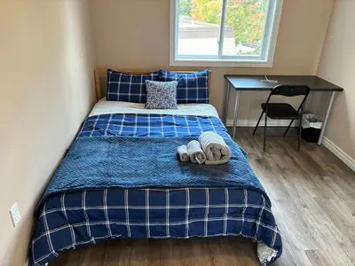 a bedroom with a bed with two slippers on it at Room in neat comfy house in Kitchener