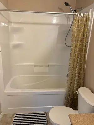a bathroom with a tub and a toilet and a shower curtain at Room in neat comfy house in Kitchener