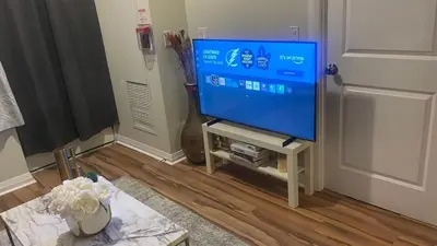 a flat screen tv sitting on a stand in a living room at Quiet Room In A Guest House in Mississauga