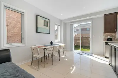 a kitchen and dining room with a table and chairs at Meadowcrest Semi in Mississauga