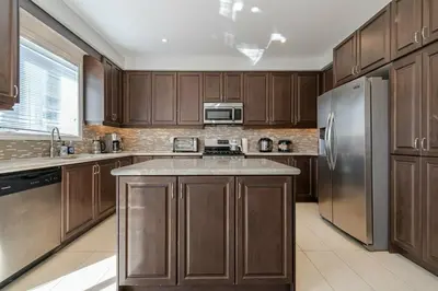 a kitchen with wooden cabinets and a stainless steel refrigerator at Meadowcrest Semi in Mississauga