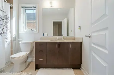 a bathroom with a sink and a toilet and a mirror at Meadowcrest Semi in Mississauga