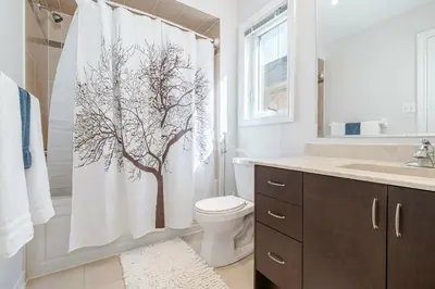 a bathroom with a shower curtain with a tree on it at Meadowcrest Semi in Mississauga