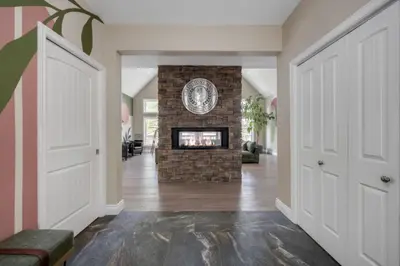 a living room with a stone fireplace in a house at LUX Lakefront Sleeps18 Pickleball HotTub Sauna Gym Arcade Basketball Volleyball in Buckhorn
