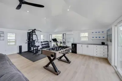 a living room with a table in the middle at LUX Lakefront Sleeps18 Pickleball HotTub Sauna Gym Arcade Basketball Volleyball in Buckhorn