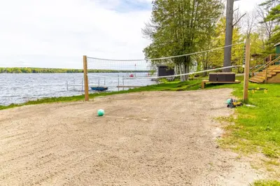 a volleyball net on the shore of a lake at LUX Lakefront Sleeps18 Pickleball HotTub Sauna Gym Arcade Basketball Volleyball in Buckhorn