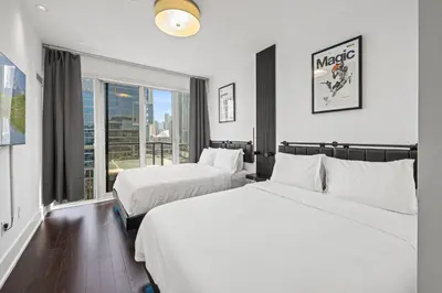 a hotel room with two beds and a window at PARC LOFT Penthouse with 4bd-WFH-PS5-CN Tower Views in Toronto