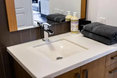 a bathroom with a sink and a mirror and towels at PARC LOFT Penthouse with 4bd-WFH-PS5-CN Tower Views in Toronto