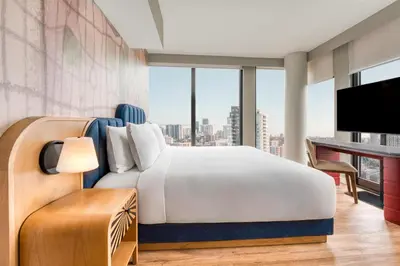 a bedroom with a bed and a desk with a television at Toor Hotel Toronto, Part Of Jdv By Hyatt in Toronto