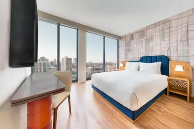 a bedroom with a bed and a desk and windows at Toor Hotel Toronto, Part Of Jdv By Hyatt in Toronto