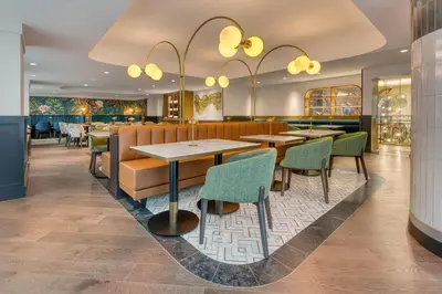 a restaurant with wooden tables and green chairs at Toor Hotel Toronto, Part Of Jdv By Hyatt in Toronto