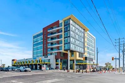 a tall building on a street corner with a traffic light at Finch West Residence Suites - Hotel DUKE in Toronto
