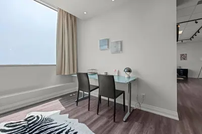 a dining room with a glass table and two chairs at Finch West Residence Suites - Hotel DUKE in Toronto