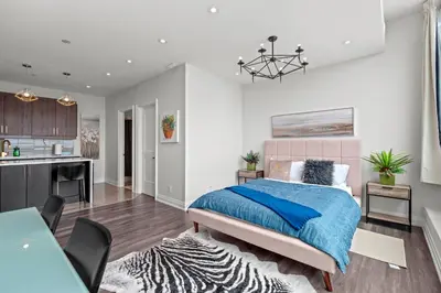 a bedroom with a large bed and a kitchen at Finch West Residence Suites - Hotel DUKE in Toronto
